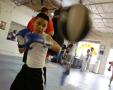 Photograph: [Boy hitting speed bag with blue boxing gloves]