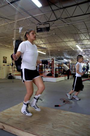 Primary view of object titled '[Girl and boy jumping rope in boxing gym]'.