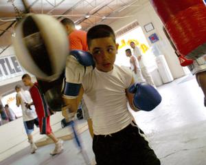Primary view of object titled '[Boy wearing blue boxing gloves]'.