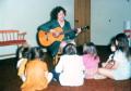Photograph: [Children watching woman with guitar in Emily Fowler Library]