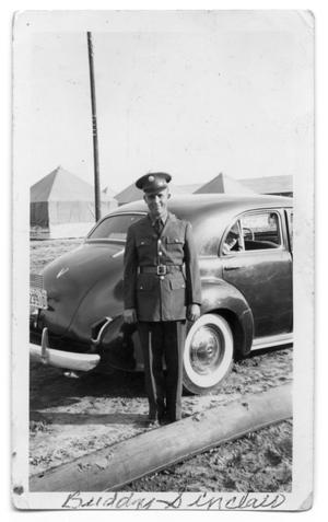 Primary view of object titled 'Buddy Sinclair standing in uniform outside car'.