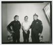 Photograph: [Lee Harvey Oswald Standing With Officers]