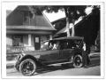 Photograph: People inside a 1921 Oldsmobile parked outside a house