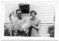 Photograph: Couple outside a house holding a baby
