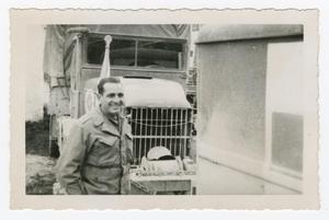 Primary view of object titled '[Dan Melli Standing in Front of a Truck]'.