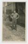 Photograph: [Soldier In Front of Warehouse]