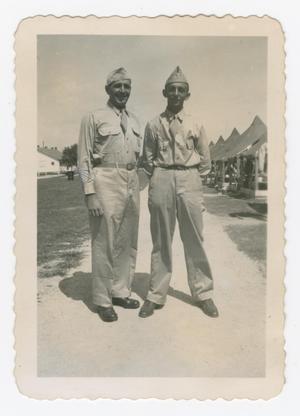Primary view of object titled '[Dan Melli and Another Soldier Standing in Front of Tents]'.