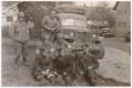 Photograph: [Four Soldiers and Three Displaced Persons with a Truck]