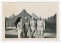 Photograph: [Four Soldiers Standing in Front of Tents]