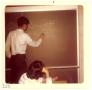 Thumbnail image of item number 1 in: '[Student writing math problem on chalkboard]'.