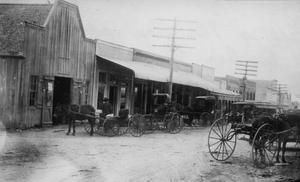 Primary view of object titled '[Blacksmith shop with buggies out front]'.