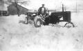 Photograph: [Man plowing snow with tractor]