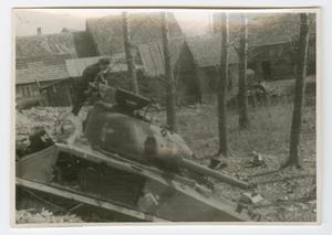 Primary view of object titled '[Richard Koos Standing on a Wrecked Tank]'.