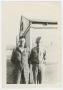 Photograph: [Two Soldiers Standing by a Hutment]