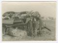 Photograph: [Two Soldiers Smoking by a Wrecked Tank]