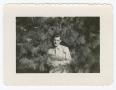 Photograph: [William Giannopoulos Standing Against an Evergreen Tree]