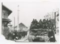 Photograph: [Soldiers Riding a Tank in a Town]