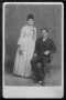 Photograph: [A young couple, man is seated and woman is standing.]