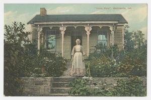 Primary view of object titled '[Postcard of an Older Woman Standing in Front of a House]'.