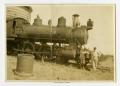 Primary view of [Two Men Leaning Against a Steam Locomotive]
