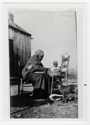 Primary view of object titled '[African American Woman, Brown Lylie, Sitting in Front of Basket]'.