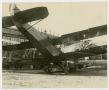Photograph: [Damaged Biplane by a Building]
