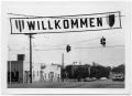 Photograph: ["Willkommen" Banner Over a Street]