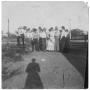 Photograph: [Men and Women Gathered at a Fence]