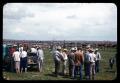 Photograph: [People in a Field near Fenced Cattle]