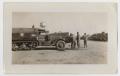 Photograph: [Three Soldiers Standing in Front of a Half-Track]