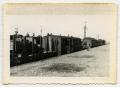 Photograph: [A German Soldier Walking Along Line of Rail Cars]