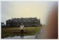 Photograph: [A Man Standing by the Zimming Barracks]
