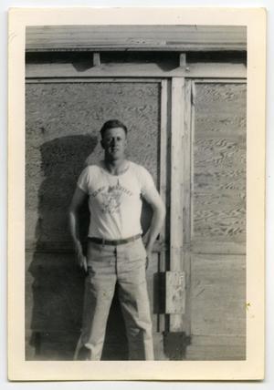 Primary view of [Photograph of Harold Wells in Front of Hut]
