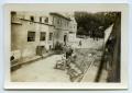 Photograph: [A Horse-Drawn Carriage Rolling Down a Street]