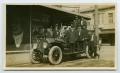 Postcard: [Postcard with a Photograph of Nine Firemen on Their Fire Truck]