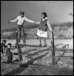 Primary view of object titled '[Bailey Woods and Sue Antoinette Emory Standing on Fence]'.