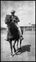 Photograph: [Boy on Horseback in Front of Brick Building]