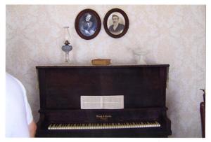Primary view of object titled '[Photograph of a Piano and Portraits in the Pound House]'.