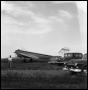 Primary view of [Airplane in a Field with Three Cars and a Man]