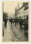 Photograph: [Photograph of a Group of People Walking Down a Street]