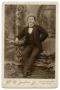 Photograph: [Portrait of a Man Sitting on a Small Bench]