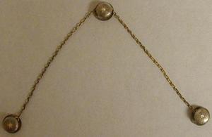 Primary view of object titled '[Three shirt studs linked to each other by a thin chain]'.