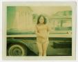 Photograph: [Photograph of a Woman Standing in Front of a Car]