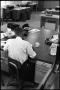 Photograph: [Man Working at Desk at Beaumont Enterprise #21]