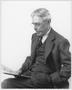 Photograph: [Albert Peyton George sitting and reading a newspaper]