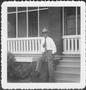 Photograph: [Mr. Albert George seated on the brick rail in front of the ranch hou…