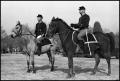 Photograph: [Two Uniformed Men Riding Horses for Fort Sill Anniversary]