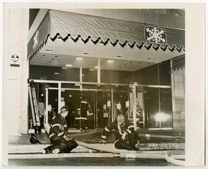 Primary view of object titled '[Two Firefighters Sit on Curb in Front of Neiman-Marcus]'.