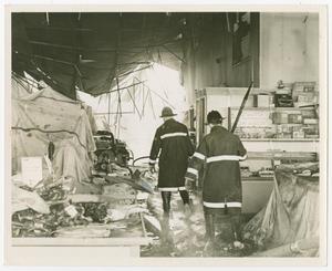 Primary view of [Two Firefighters Walk Through a Destroyed Store]