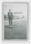 Photograph: [Photograph of Harry Lloyd Desmond Standing Next to a Road Sign]